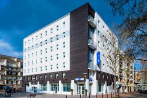 a large white building on a city street at ibis budget Issy Les Moulineaux Paris Ouest in Issy-les-Moulineaux