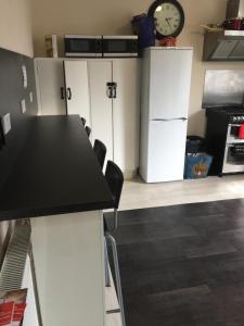 a kitchen with a black counter top and a refrigerator at Edinburgh West Side Hostel in Edinburgh