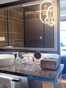 Un baño con encimera con lavabo y espejo. en 凤凰县三三民宿, en Hanqiyu