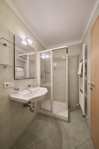 a bathroom with a sink and a shower at Zimmervermietung Zum Weissen Rössl in Sarntal