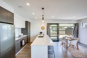 a kitchen with a white counter and a table at Quiet on Cassin - Taradale in Napier