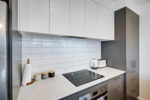 a kitchen with white cabinets and a sink at Quiet on Cassin - Taradale in Napier +23 photos