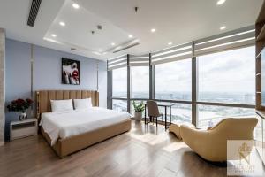 a bedroom with a bed and a table and chairs at The Majesty Landmark 81 Residence in Ho Chi Minh City