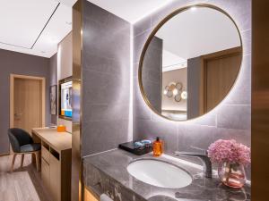 een badkamer met een wastafel en een spiegel bij Orange Chengdu Jinniu Wanda Hotel in Chengdu