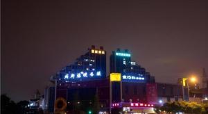 a building with blue lights on top of it at night at City Comfort Inn Chengdu Giant Panda Base in Chengdu