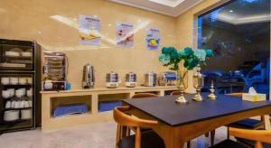 a dining room with a table and chairs and a counter at Shell Hotel Changzhou North Railway Station Global Harbor Metro Station in Changzhou