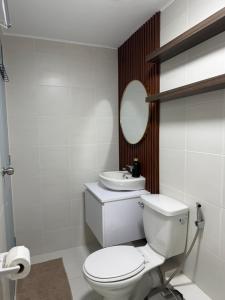 Un baño blanco con inodoro y lavabo. en The UrbanNest, en Piapi