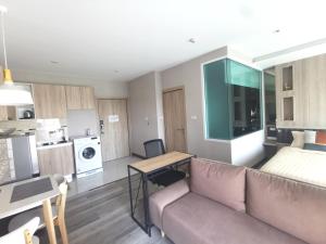 a living room with a couch and a table and a kitchen at The new concept office plus in Ban Fon +4 photos