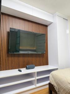 a tv hanging on a wall in a bedroom at The UrbanNest - 1BR Condo in Marina Spatial, Dumaguete with free fast WiFi and Pool in Piapi