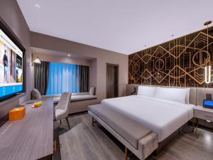 een hotelkamer met een groot bed en een tv bij Orange Chengdu Jinniu Wanda Hotel in Chengdu +23 foto's