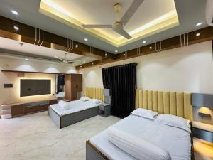 a bedroom with two beds and a flat screen tv at Iconic Suites in Chittagong