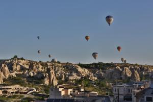 a group of hot air balloons flying over a mountain at Turquaz Cave Hotel in Göreme