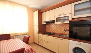eine Küche mit einem Tisch, einer Spüle und einer Mikrowelle in der Unterkunft Apartman-studio Adriana 3 in Lovran