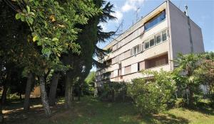 un edificio blanco con árboles delante de él en Apartman-studio Adriana 3 en Lovran