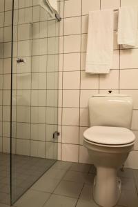 a bathroom with a toilet and a shower with towels at Horten Budget Hotel in Horten