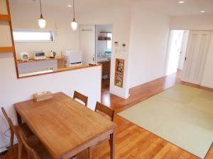 a kitchen and dining room with a table and chairs at Lulumalu AMAMI in Amami
