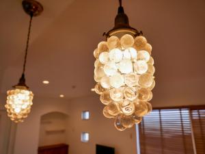 a bunch of glass lights hanging from a ceiling at Lulumalu AMAMI in Amami +42 photos