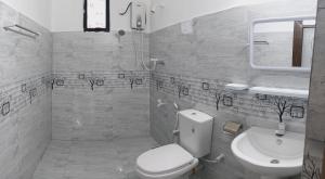 a bathroom with a white toilet and a sink at Didula Holiday Resort Anuradhapura in Anuradhapura +8 photos