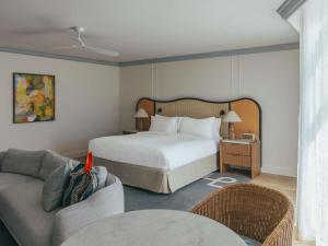 努萨角Elysium Noosa Resort - MGallery Collection的一间酒店房间，里面有一张床和一张沙发 更多47张照片