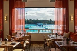 Waterfront High Rise 5 Beds 2 Car Parks في سيدني: مطعم بطاولات وإطلالة على المسبح