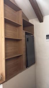 a kitchen with a black refrigerator and wooden shelves at Apartamento tipo loft in Guarne +19 photos