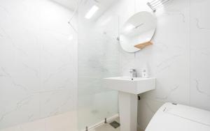 a white bathroom with a sink and a mirror at Noble Hotel in Yeosu +47 photos