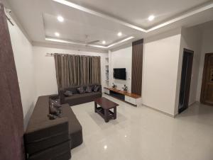 a living room with a couch and a table at Elite Homes in Chikmagalūr
