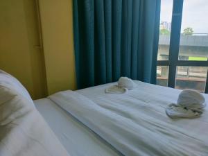 a bed with towels on top of it with a window at Swing & Pillows - Sentul in Kuala Lumpur