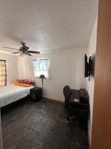 a bedroom with a bed and a ceiling fan at The Gray House  +2 photos