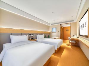 Postel nebo postele na pokoji v ubytování JI Hotel Hangzhou Xiasha Jinsha Lake