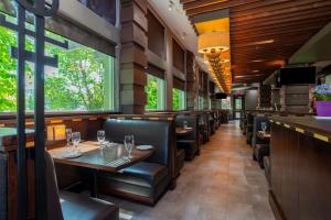 un restaurante con mesas, sillas y ventanas en Sandman Suites Surrey - Guildford, en Surrey