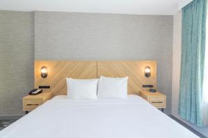 Un dormitorio con una cama grande y dos mesitas de noche. en Sandman Suites Surrey - Guildford, en Surrey 18 fotos más