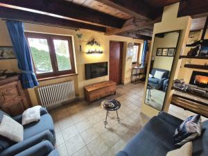 un soggiorno con 2 divani blu e una TV di Chalet Grande Cerise - vicino ad Aosta e Pila a Gressan Altre 44 foto