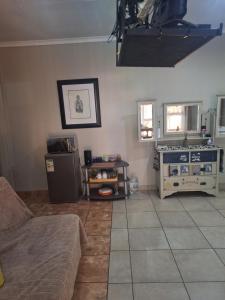 a living room with a couch and a stove at SMAPERS GUESTHOUSE in Brits