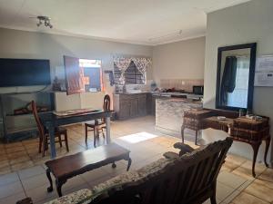 a living room with a table and a kitchen at SMAPERS GUESTHOUSE in Brits