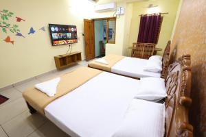 a bedroom with two beds and a tv at Bluetique Beach House in Kuilapayam