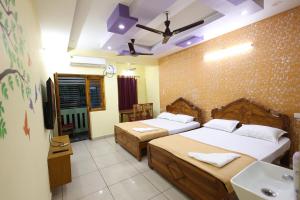 a bedroom with two beds and a sink in it at Bluetique Beach House in Kuilapayam