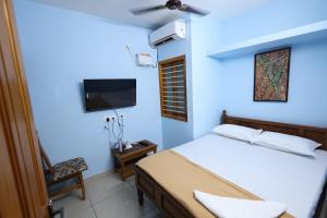 a bedroom with a bed and a flat screen tv at Bluetique Beach House in Kuilapayam +8 photos