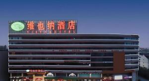 a building with a sign on the top of it at Vienna Hotel Shandong Dezhou Government Shopping Plaza in Songguantun