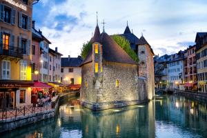 アヌシーにあるZenitude Hôtel-Résidences Les Hauts d'Annecyの都市の川の古い建物