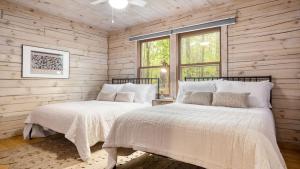 two beds in a room with wooden walls at Half Moon by AvantStay 4BR Cabin w Large Deck Yard w Patio Outdoor Dining in Great Barrington
