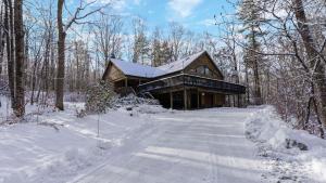 a log cabin in the woods in the snow at Half Moon by AvantStay 4BR Cabin w Large Deck Yard w Patio Outdoor Dining in Great Barrington