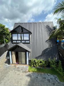 ein kleines Haus mit schwarzem Dach in der Unterkunft Mangalath River View Resorts in Kodanad