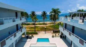 an apartment building with a swimming pool and the ocean at THE SHORELINE SUBIC HOTEL in Olongapo