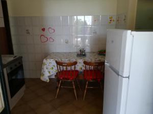 アチレアーレにあるResidenza Orsolaのキッチン(テーブル、椅子2脚、冷蔵庫付)