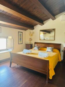 a bedroom with a large bed with yellow sheets at Il Casale di Luisa in Modica +55 photos
