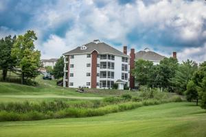 a large white building on a golf course at Greensview Branson by Exploria Resorts in Branson