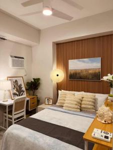 The Modern Nest Condo في مدينة سيبو: غرفة نوم مع سرير كبير ومكتب مع مكتب