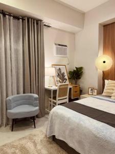 The Modern Nest Condo في مدينة سيبو: غرفة نوم بها سرير ومكتب وكرسي