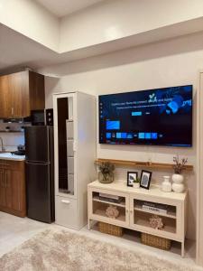 The Modern Nest Condo في مدينة سيبو: مطبخ مع شاشة تلفزيون مسطحة كبيرة على الحائط